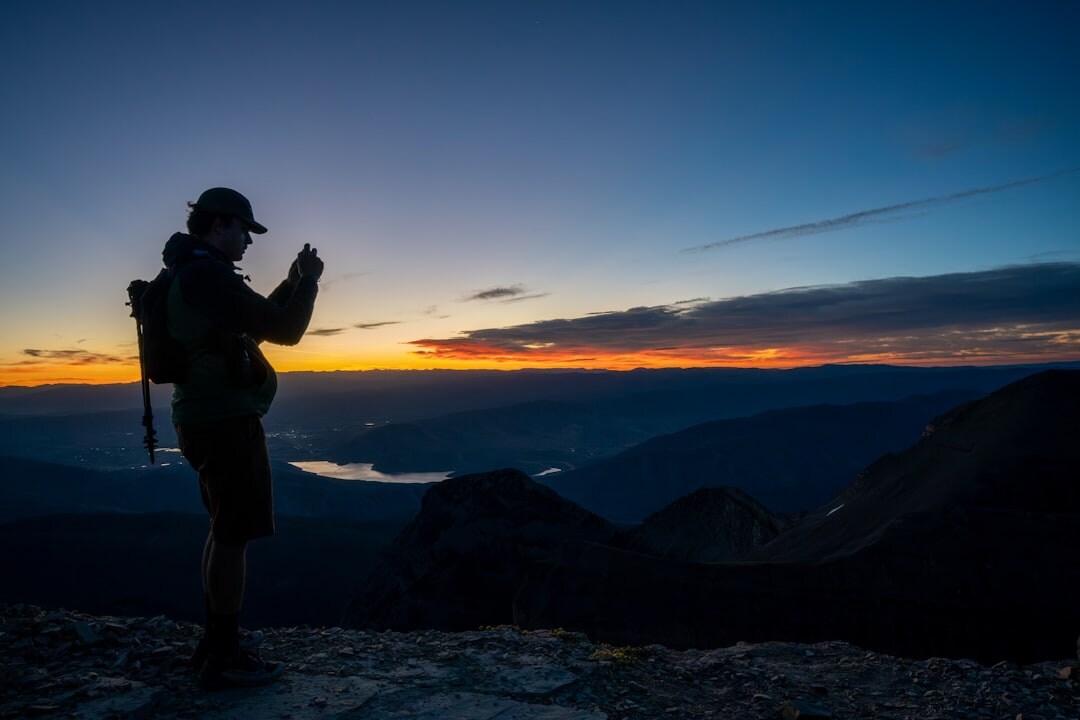person on mountain peak at sunrise