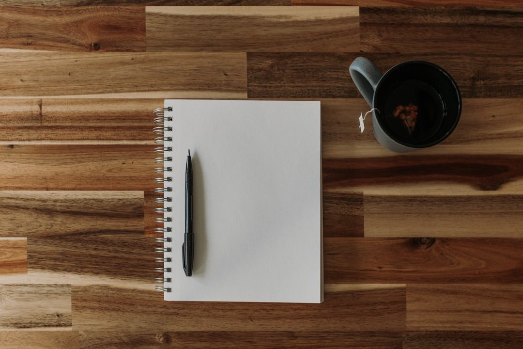 Open journal notebook with a pen and coffee cup